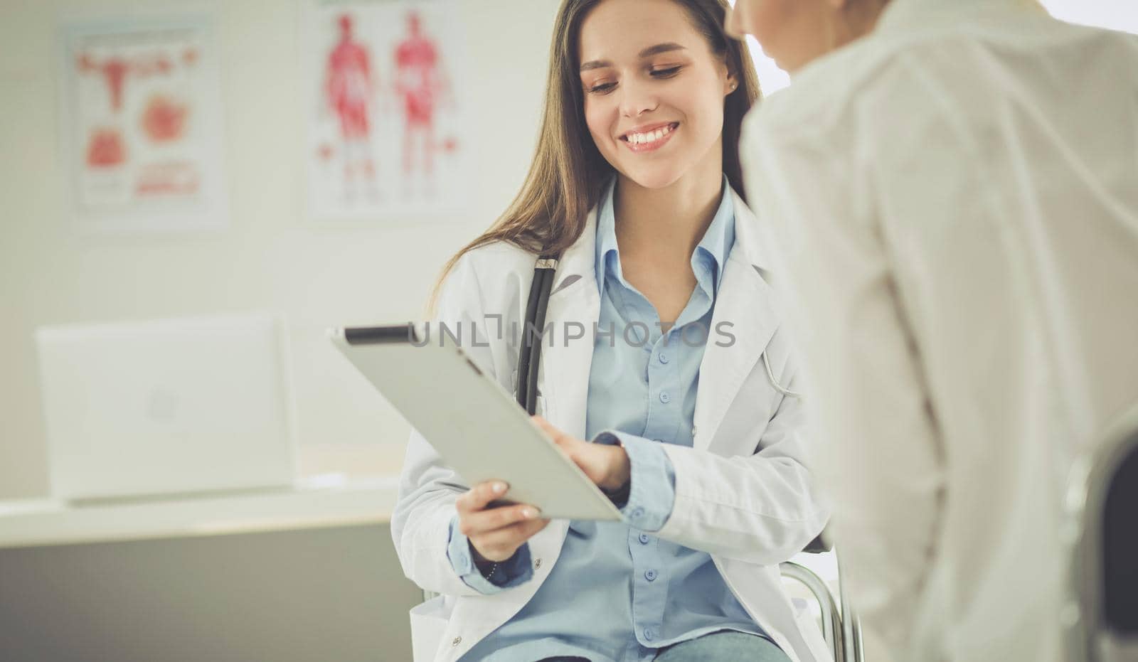 Doctor and patient discussing something while sitting at the table . Medicine and health care concept.