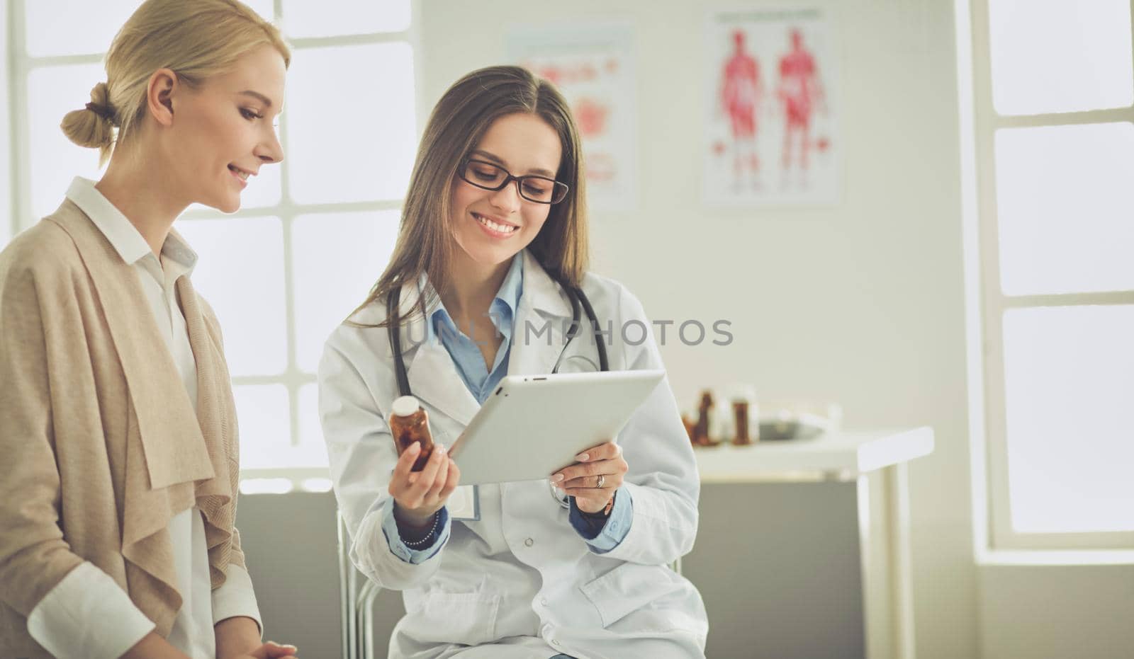 Doctor and patient discussing something while sitting at the table . Medicine and health care concept.