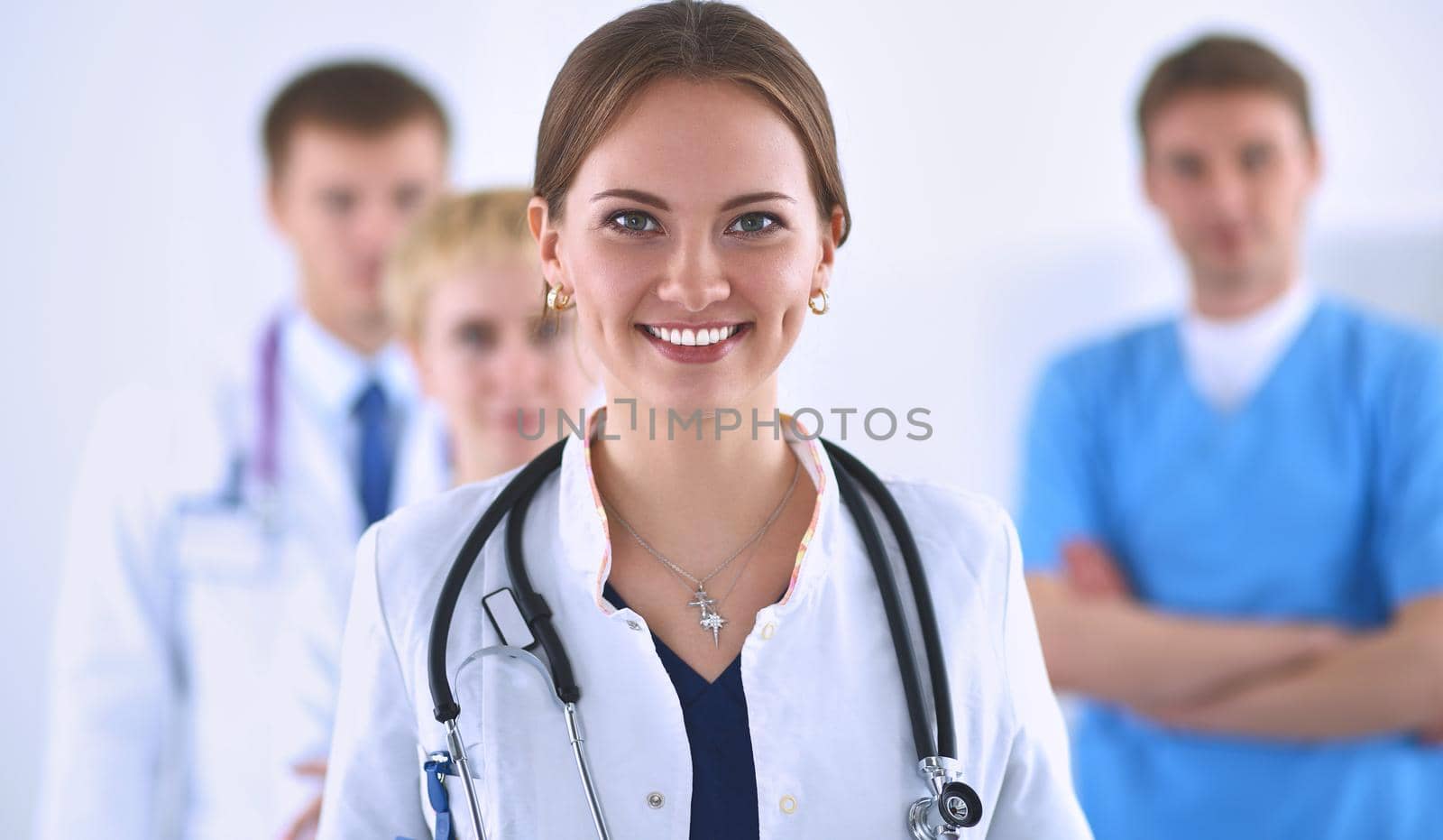 Attractive female doctor in front of medical group .