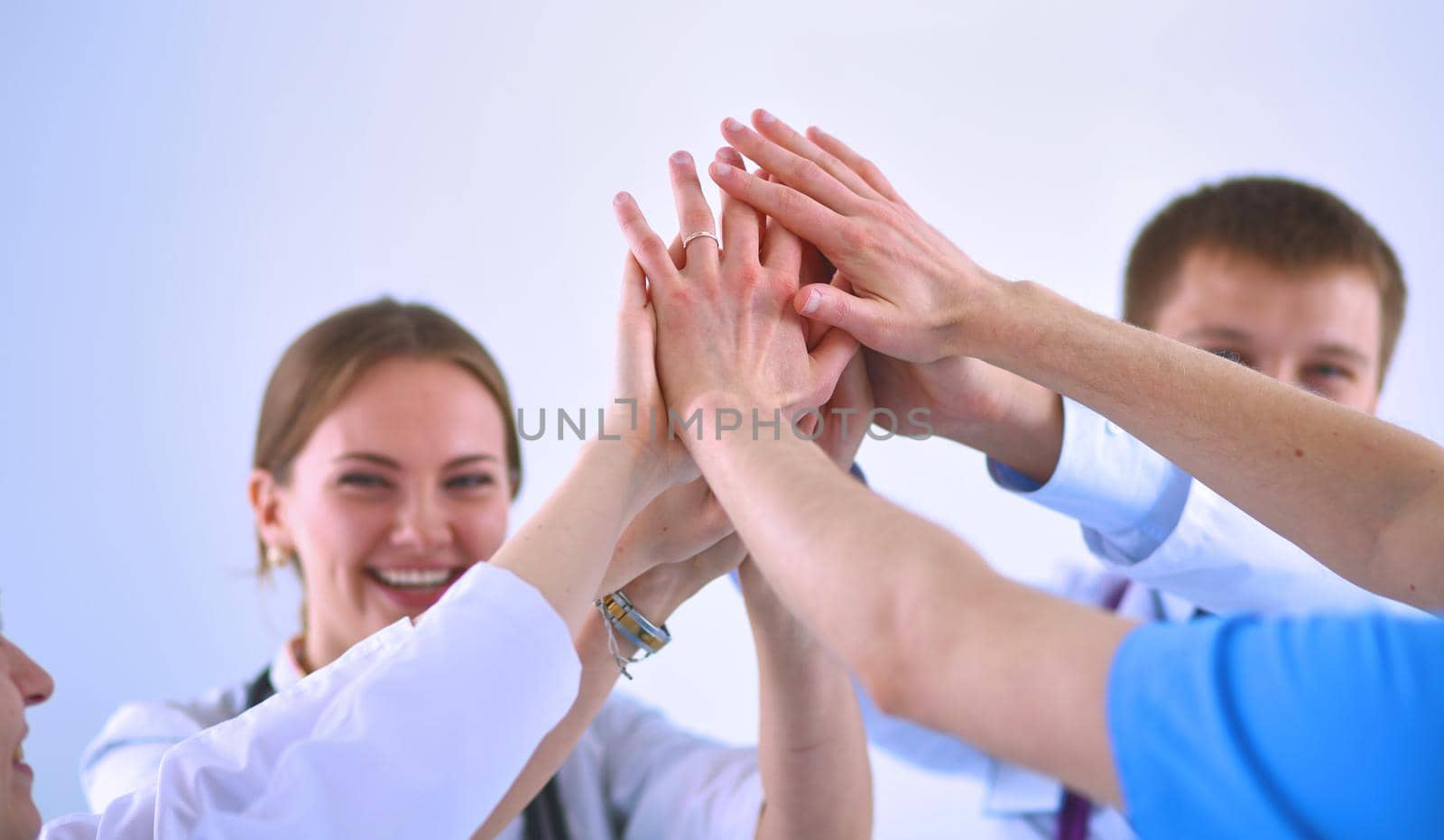 Doctors and nurses in a medical team stacking hands .