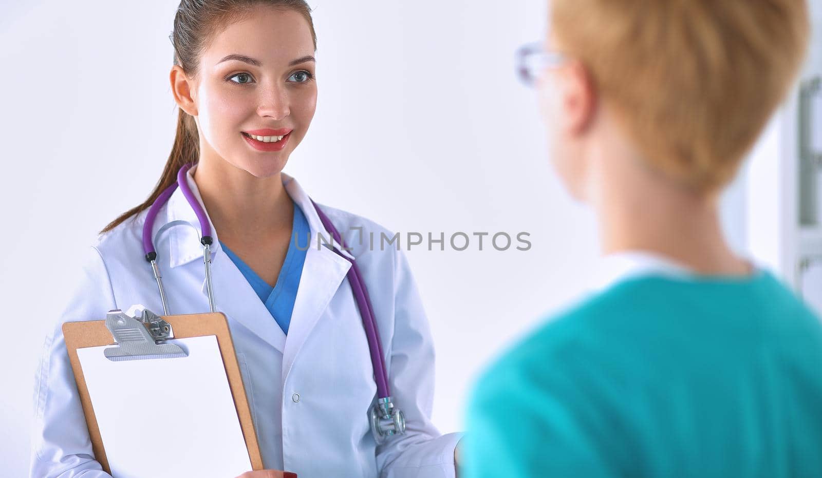 Woman doctor standing with folder at hospital .