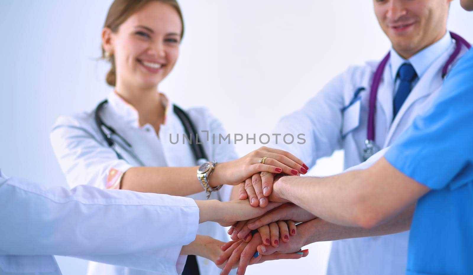 Doctors and nurses in a medical team stacking hands .