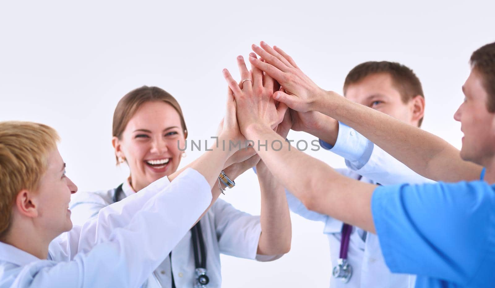 Doctors and nurses in a medical team stacking hands .