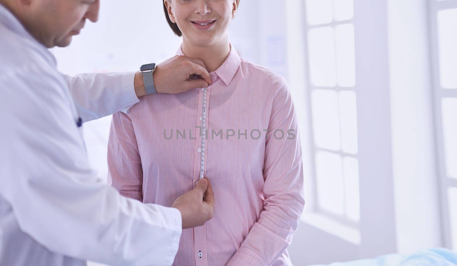 Doctor showing young patient her chest in his office at the hospital.