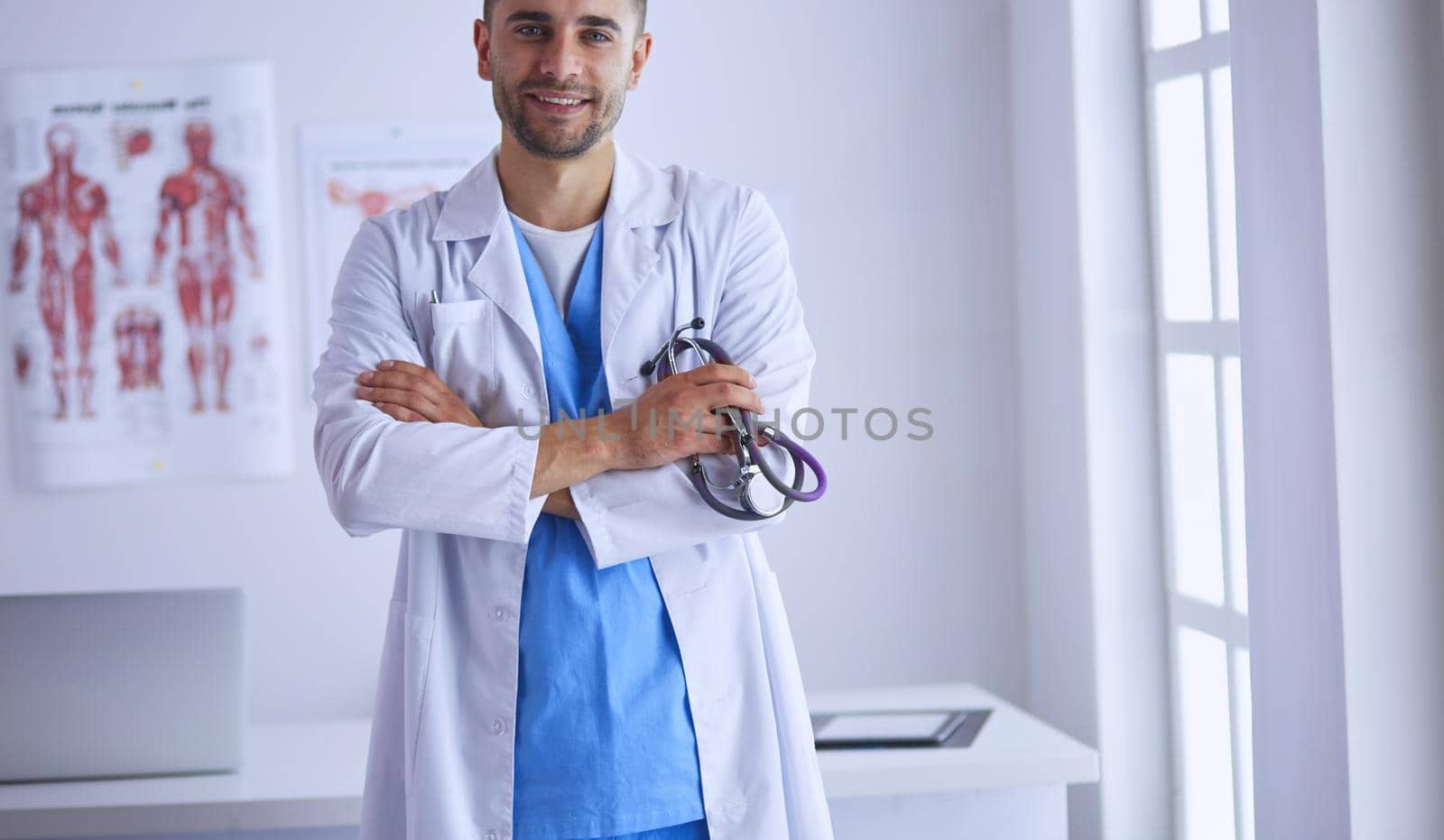 Young and confident male doctor portrait standing in medical office