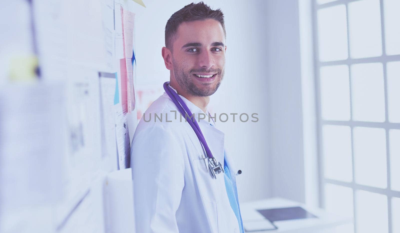 Young and confident male doctor portrait standing in medical office