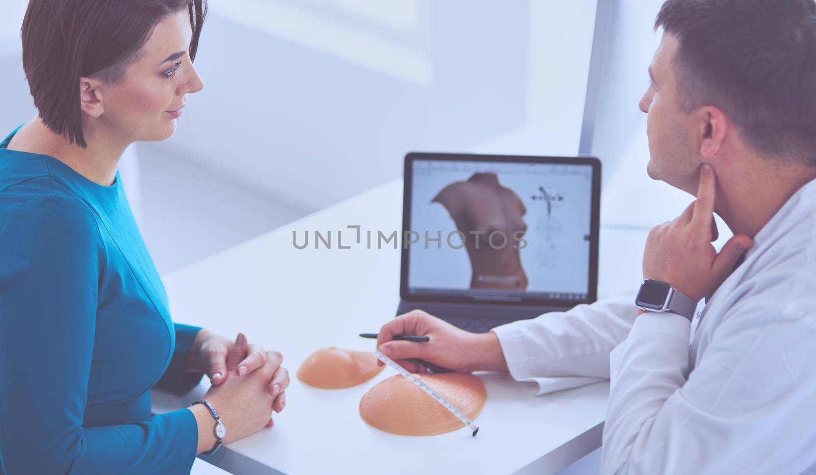 Doctor showing young patient her chest xray in his office at the hospital.