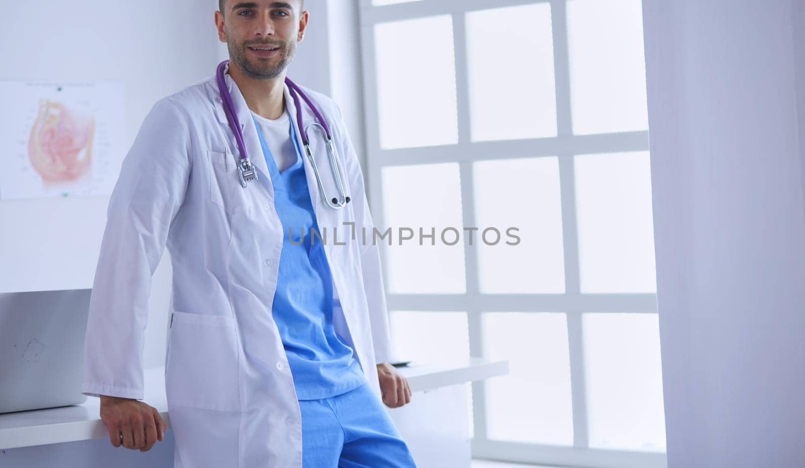 Young and confident male doctor portrait standing in medical office