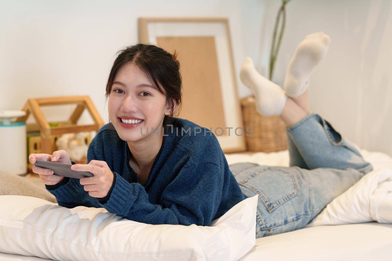 Young woman playing games on smartphone. Woman using video streamning. technology and people concept