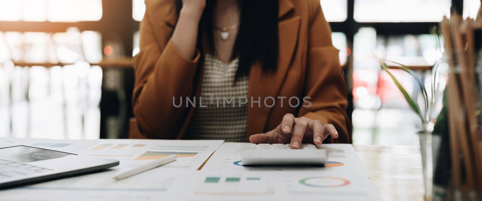 Business woman using calculator with computer laptop, Business accounting, budget and loan paper in office
