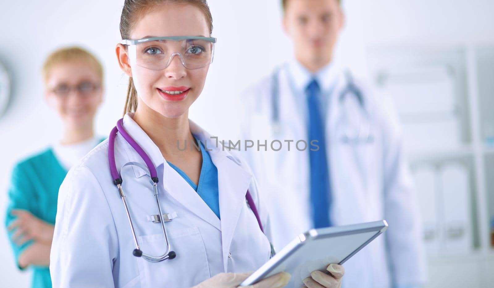 Woman doctor standing with folder at hospital .