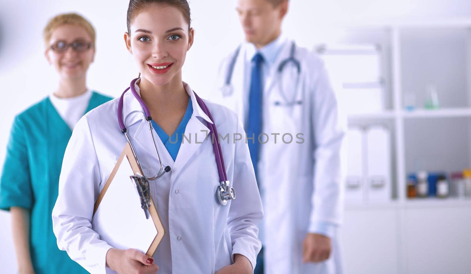 Attractive female doctor in front of medical group .