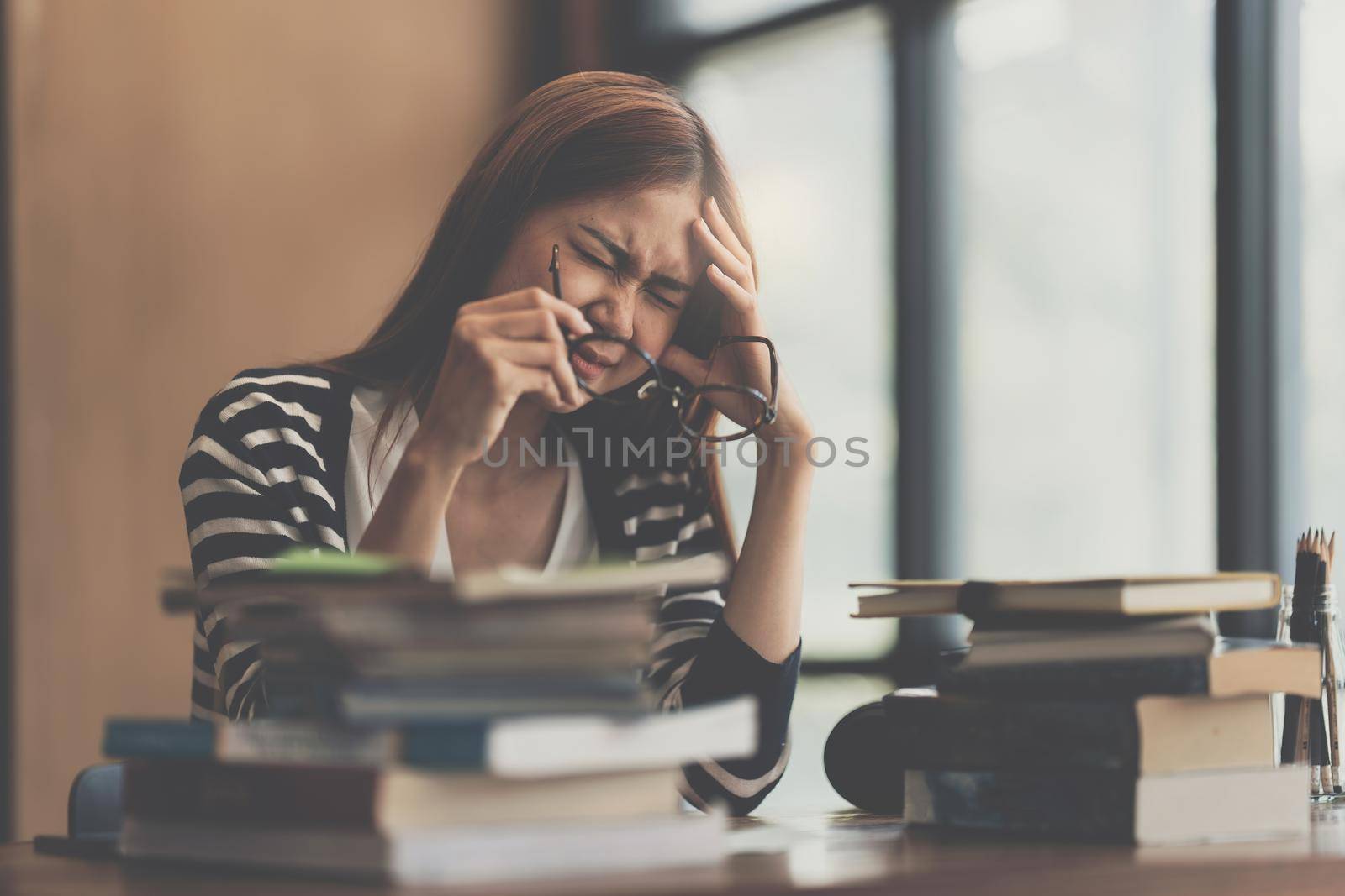 Image of Young woman stressed while reading a book for exam at library at school. back to school concept
