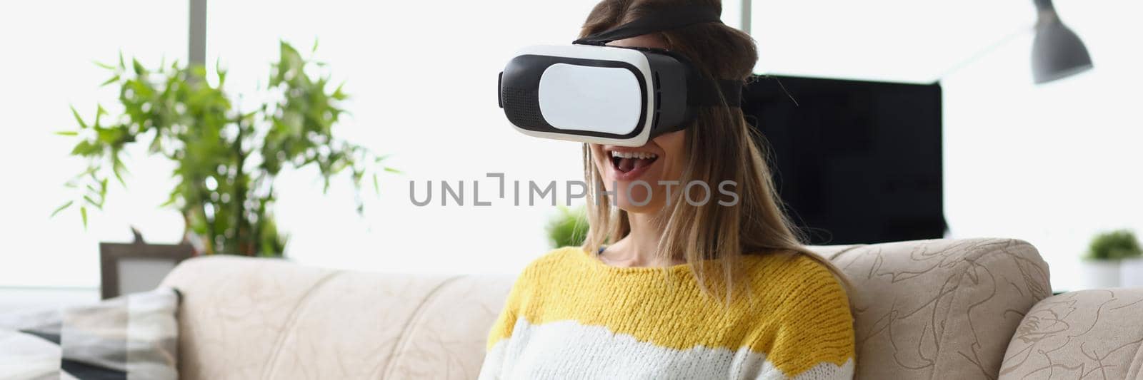 Portrait of female sit on sofa wear vr glasses modern device, enjoy spare time in imagination world. Visual effects, fun leisure. Entertainment concept