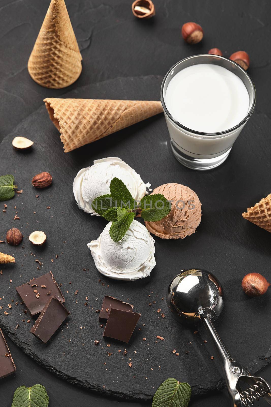 Gourmet creamy and chocolate ice cream served on a stone slate over a black background. by nazarovsergey