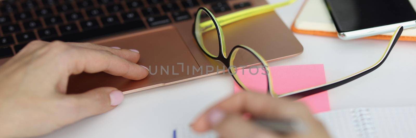 Close-up of male hold pen and make notes in notebook, plan day, working at laptop. Man office clerk, employee at work. Journal, creativity, writer concept