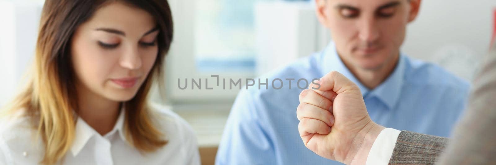 Portrait of businessman hand threatens his hired employees, coworkers looking down, feeling guilty. Strict boss give warning to clerks. Discipline concept