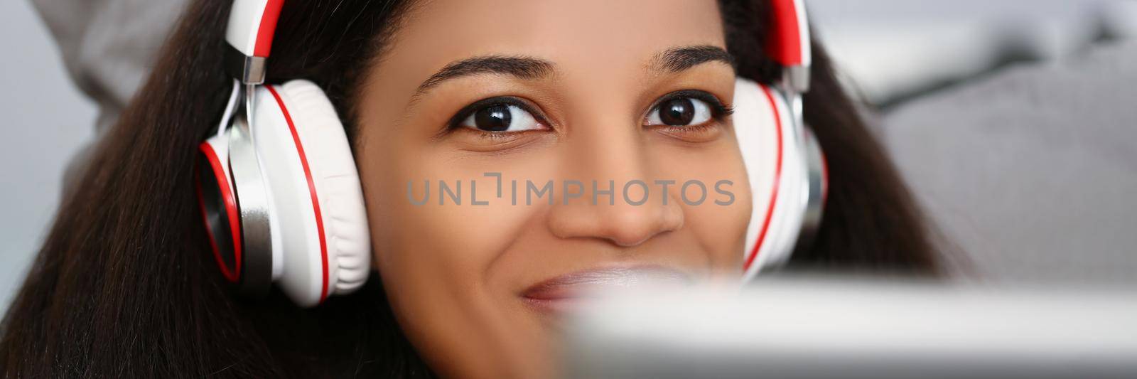 Portrait of latino american young woman wear headset and watch movie or take online class. Smiling female on remote education from home. Technology concept