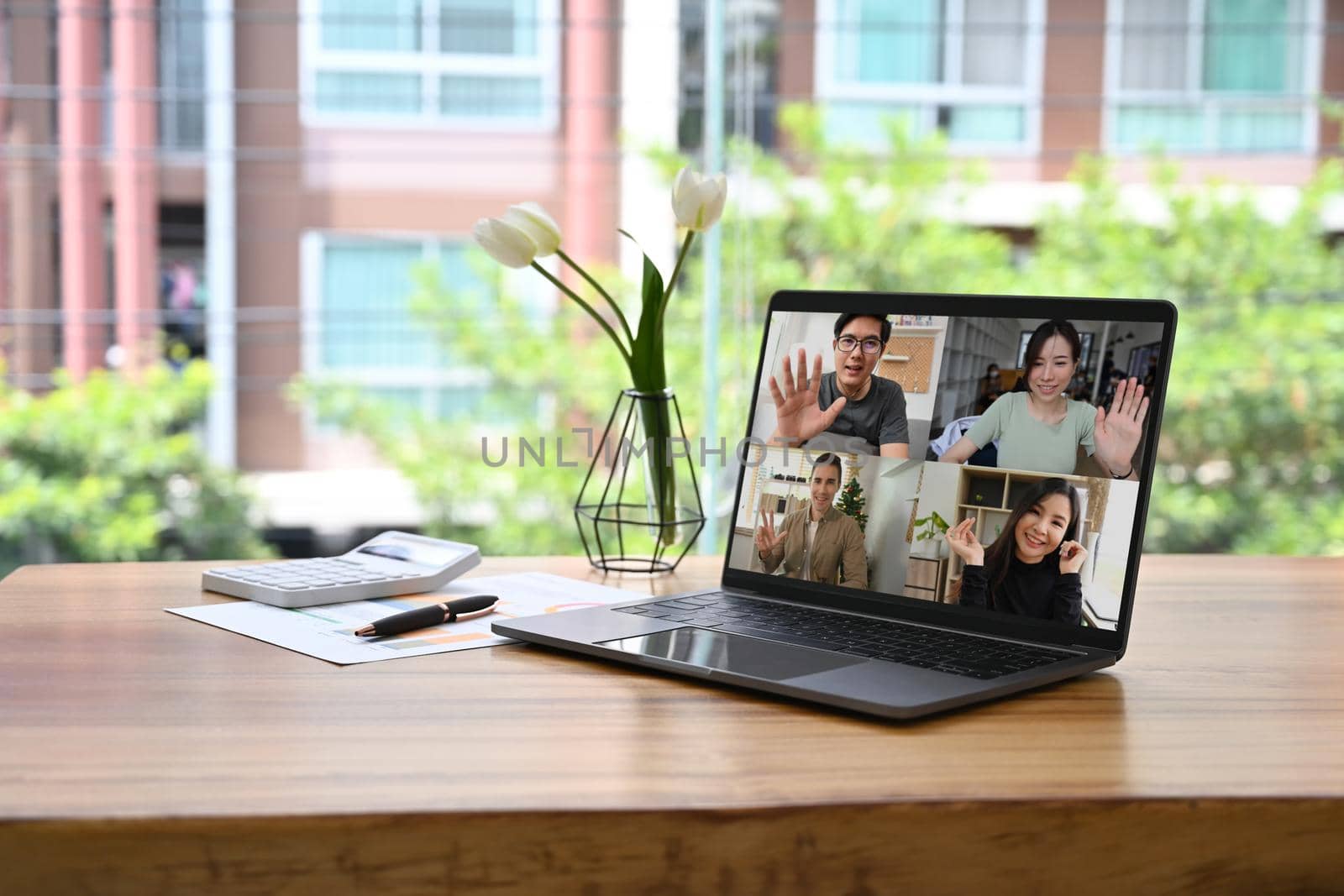 Laptop computer with diverse people involved at video conference negotiations activity by prathanchorruangsak