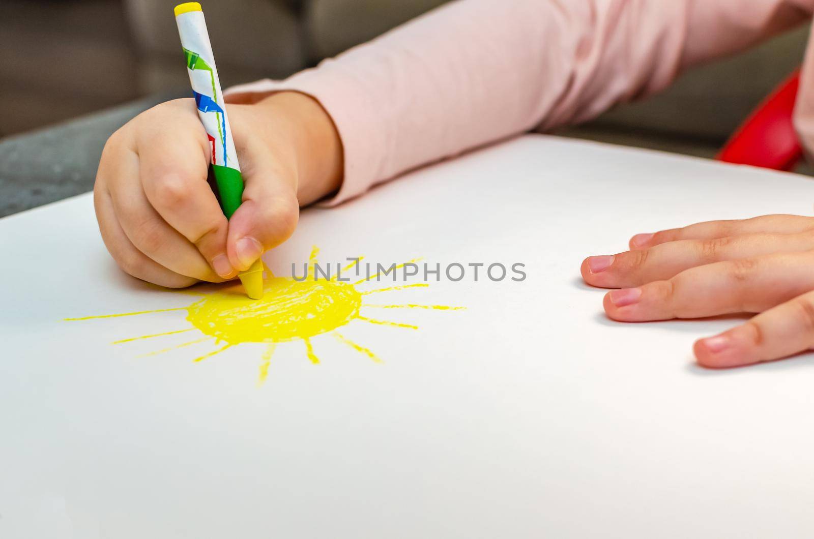 Education and school. Education and kindergarten concept. Cute little girl draws the sun with pencils.