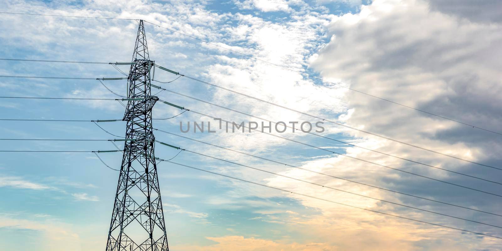 High voltage pillar. Power grid pole against the sky. High voltage tower. Electricity use and electricity cost concept by SERSOL