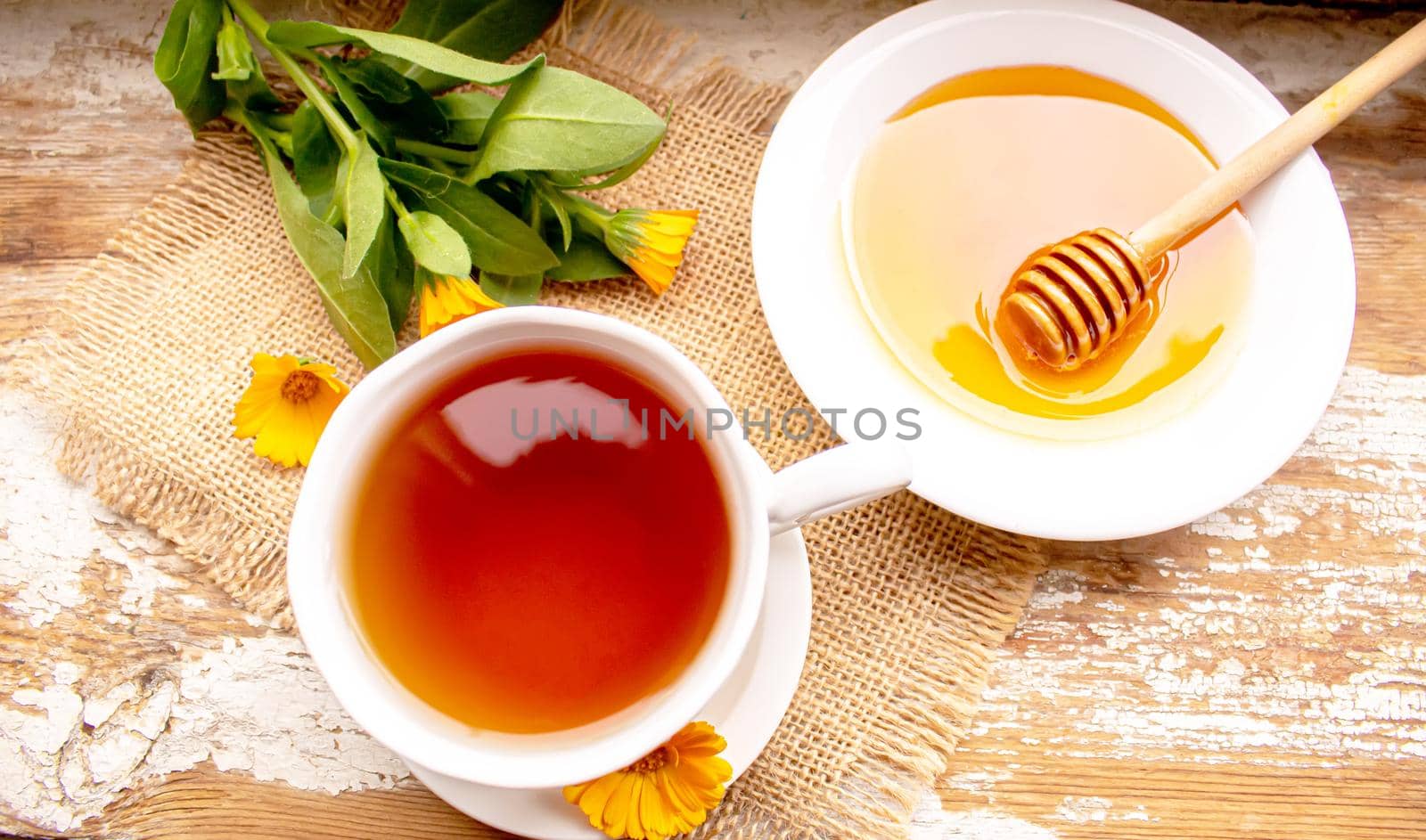 honey with dandelions. cup of tea with dandelion. selective focus. by mila1784