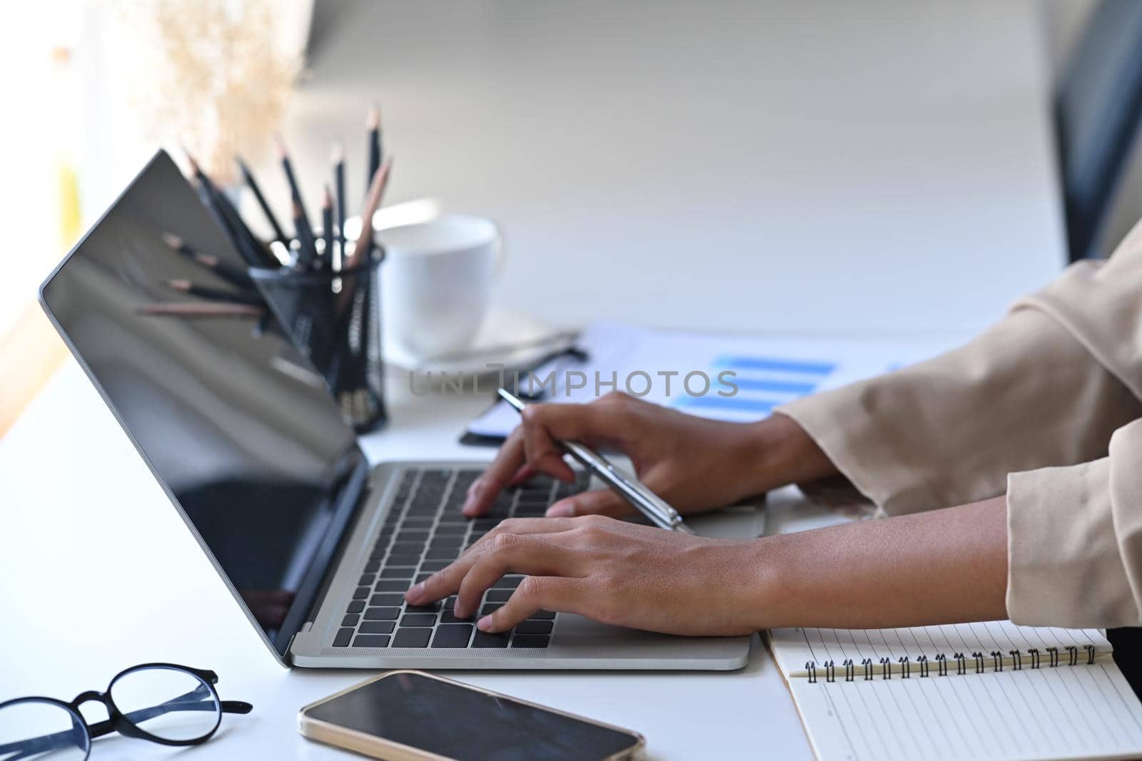 Cropped shot businesswoman hands typing on keyboard of laptop computer. by prathanchorruangsak