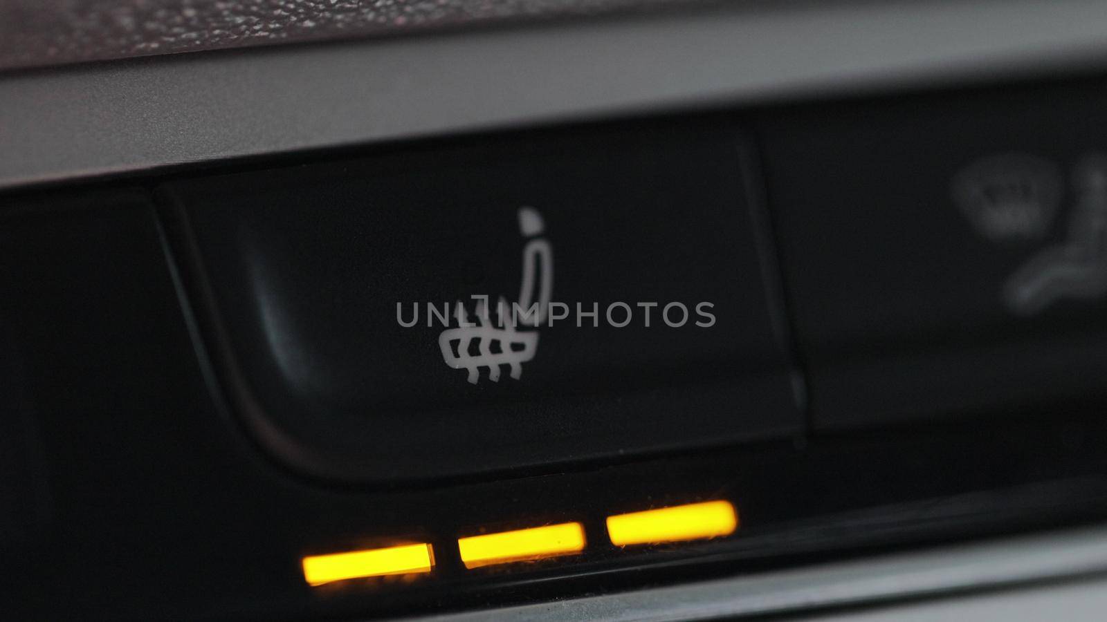 Turning on the seat heating button in the car. Switching ON heated seats of car by pressing the buttons. Heated seat dashboard in a car. by uflypro