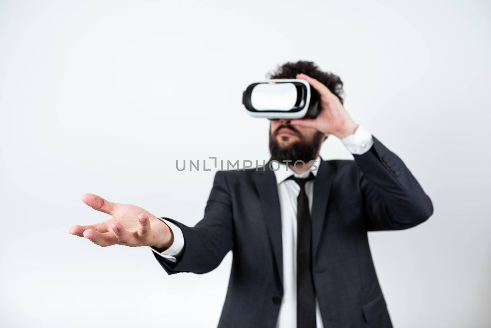 Man Wearing Vr Glasses And Presenting Important Messages Over One Hand. Businessman Having Virtual Reality Eyeglasses And Showing Crutial Informations Above Palm. by nialowwa