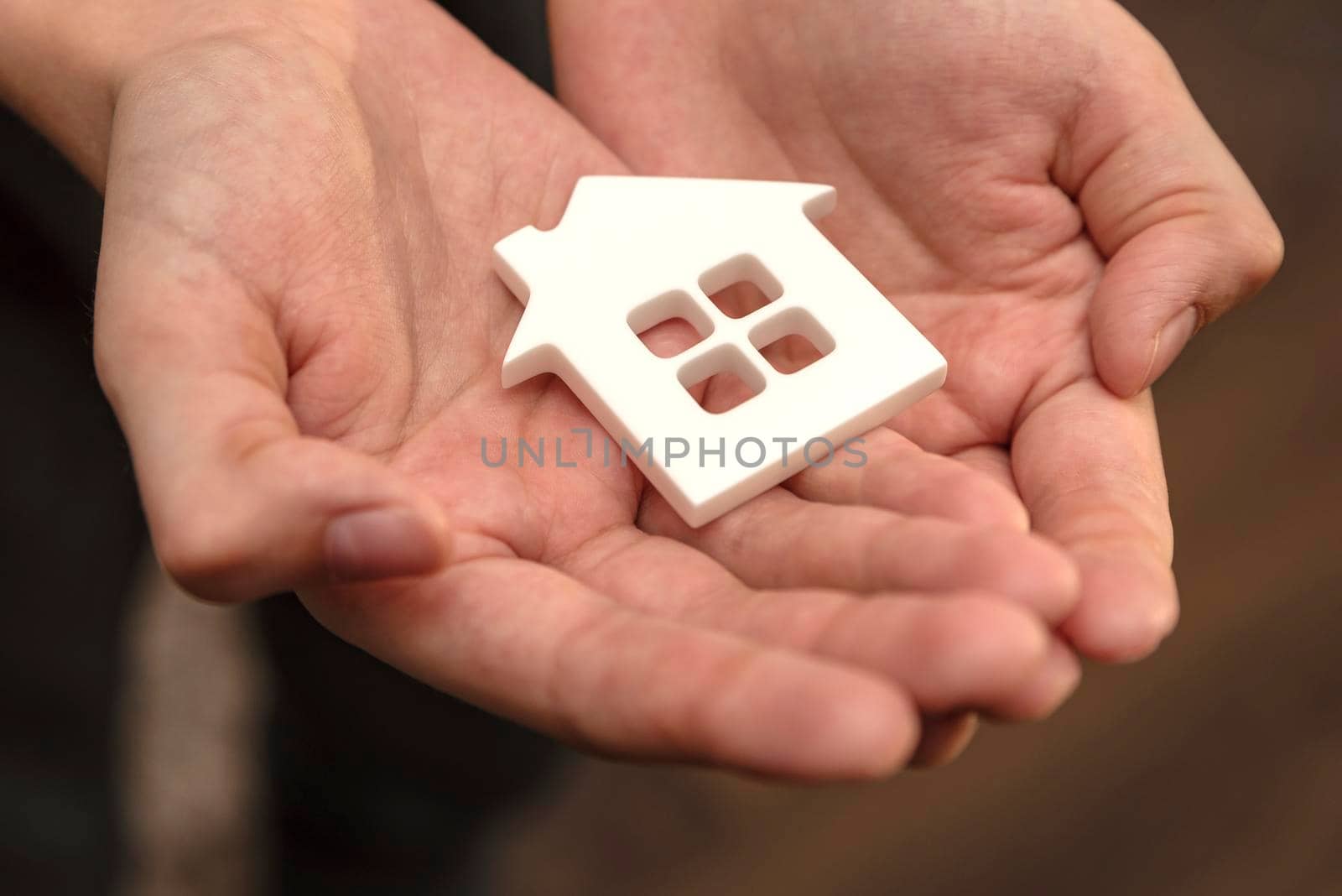 Hands are holding a toy house. Real estate purchase, homeless housing and real estate, family home insurance concept. space for text by SERSOL