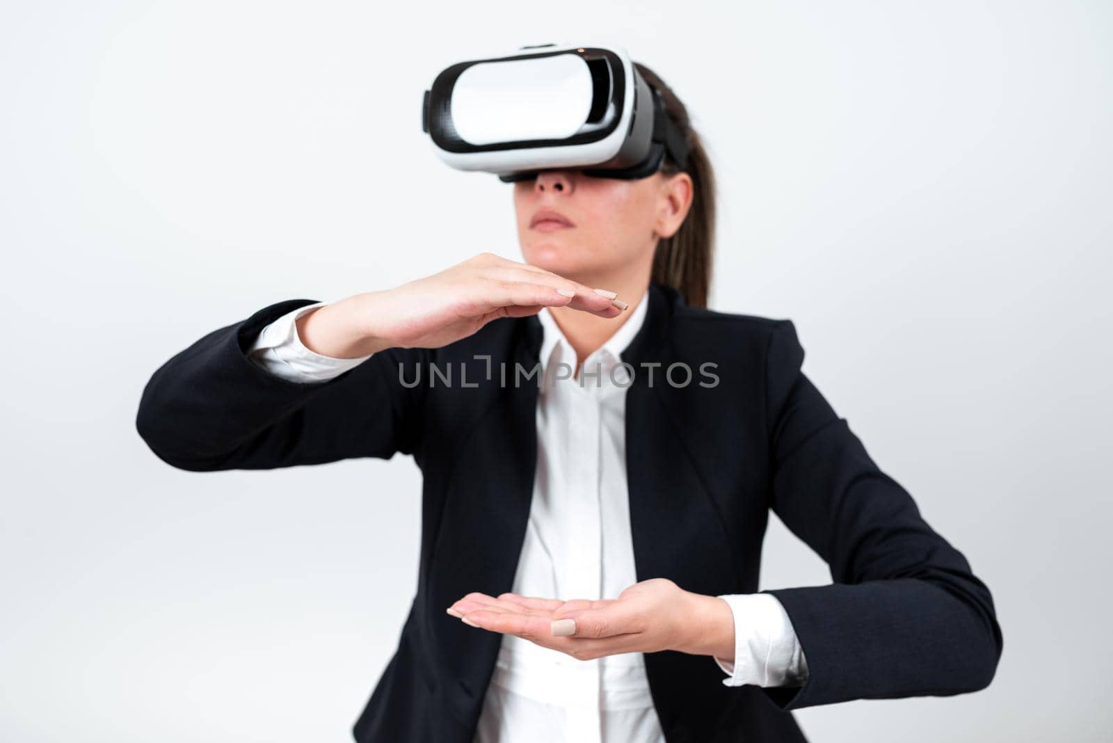 Woman Wearing Vr Glasses And Presenting Important Messages Between Hands. Businesswoman Having Virtual Reality Eyeglasses And Showing Crutial Informations. by nialowwa