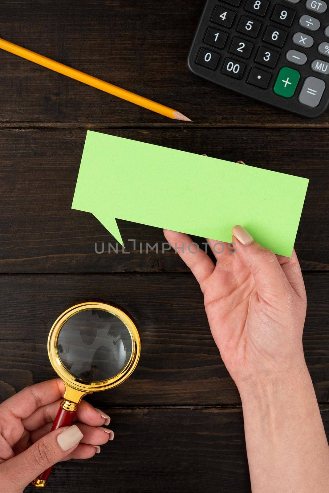 Hands Of Businesswoman With Thought Bubble Paper And Stationery Over Wooden Background. Woman Holding Pastel Color Sheet With Copy Space For Business Branding And Promotion. by nialowwa