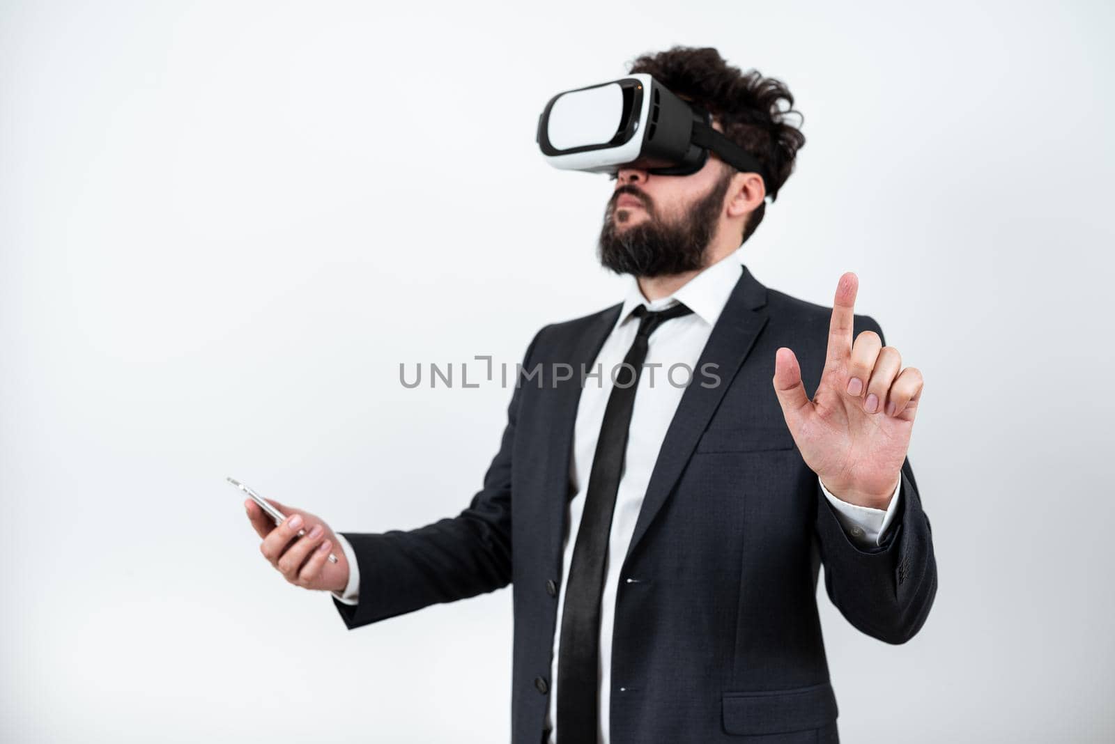 Man Wearing Vr Glasses And Pointing On Important Messages With One Finger. Businessman Having Virtual Reality Eyeglasses And Showing Crutial Informations. by nialowwa