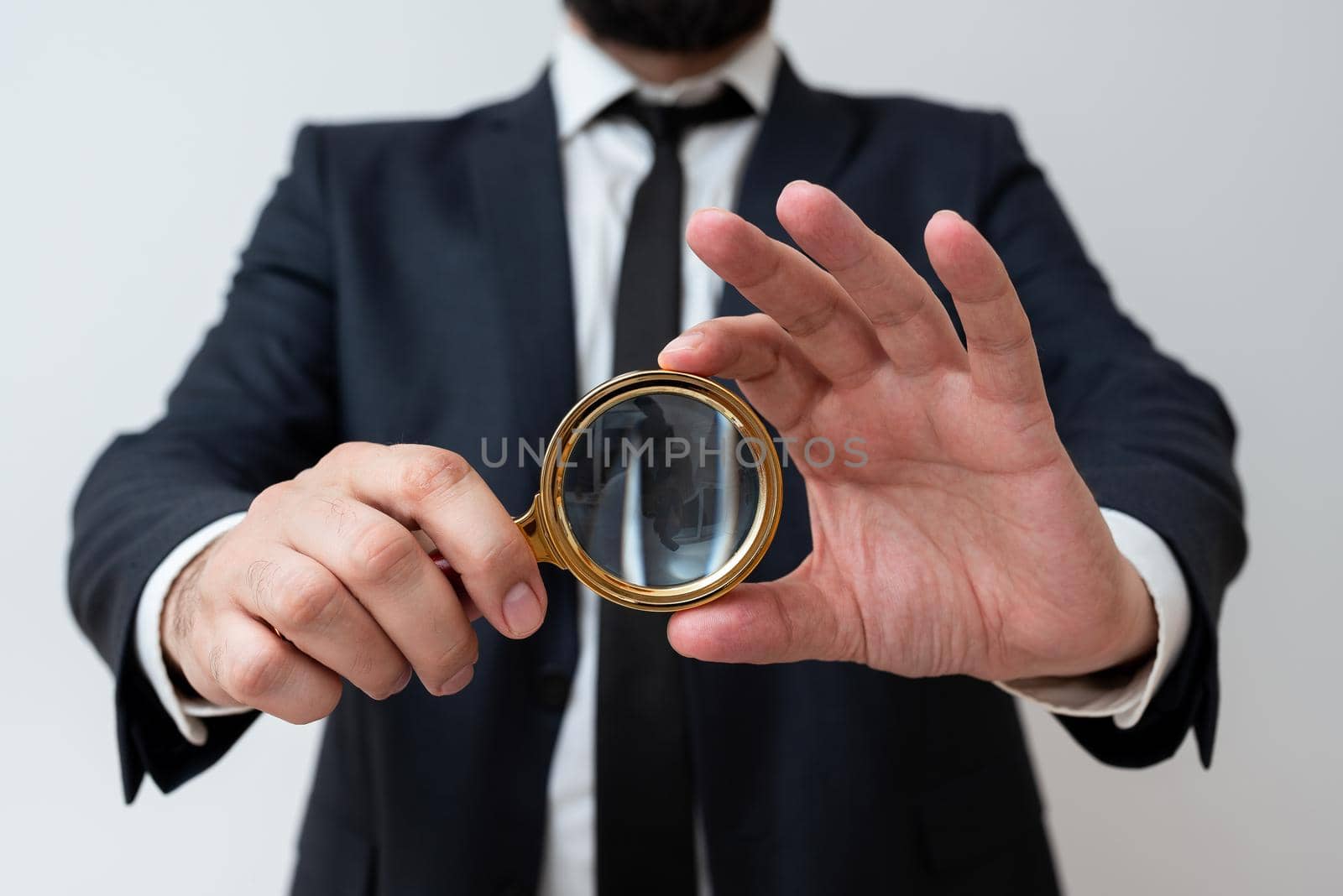 Businessman Holding Magnifier With Both Hands. Man Having Magnifying Glass To Point Important Information. Gentleman Zooming Crutial Message. Executive Presenting New Idea. by nialowwa