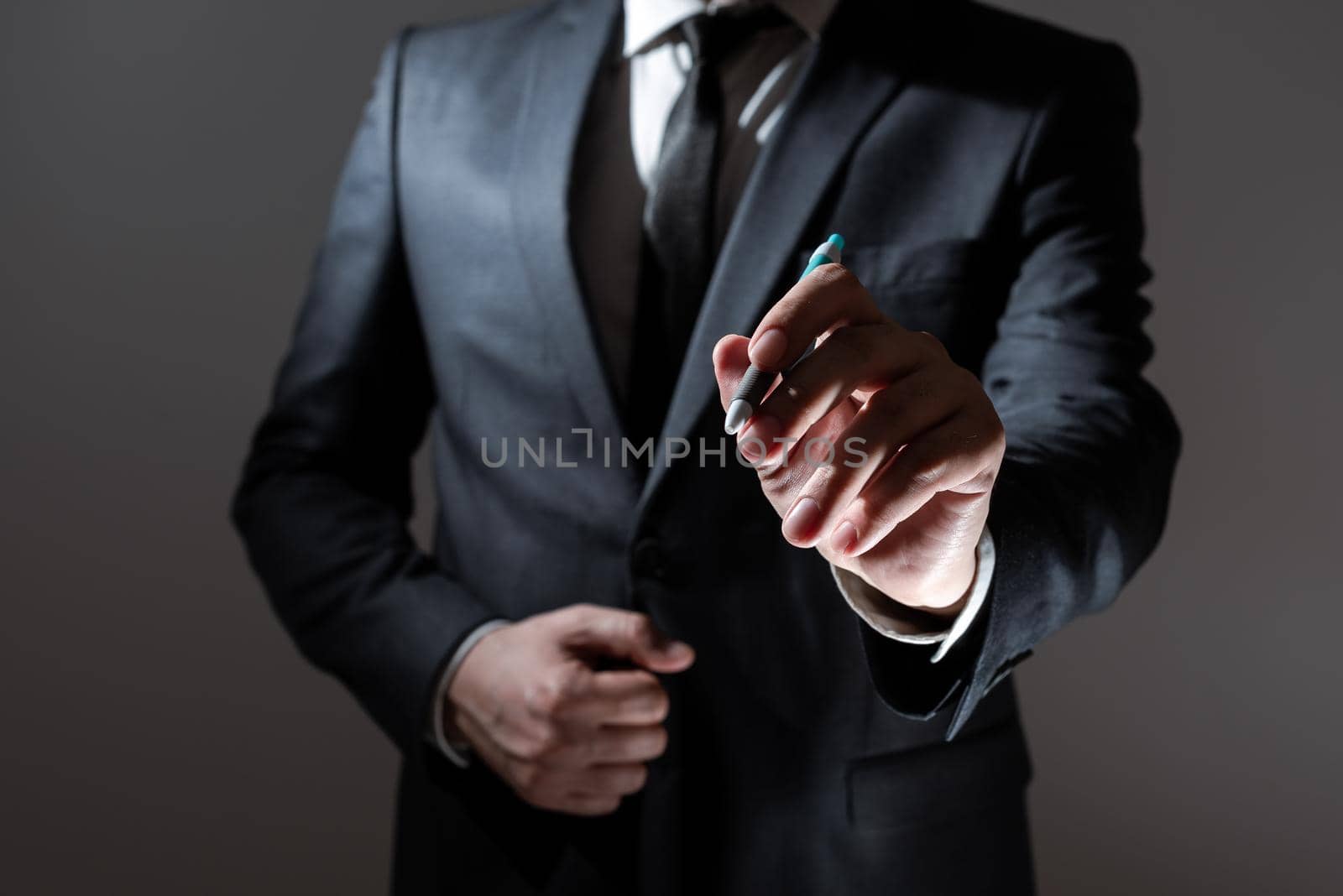 Businessman Holding Pen And Presenting Important Informations. Man In Suit Showing Crutial Announcements With Pencil In Hand. Executive Dispalying Critical Messages. by nialowwa
