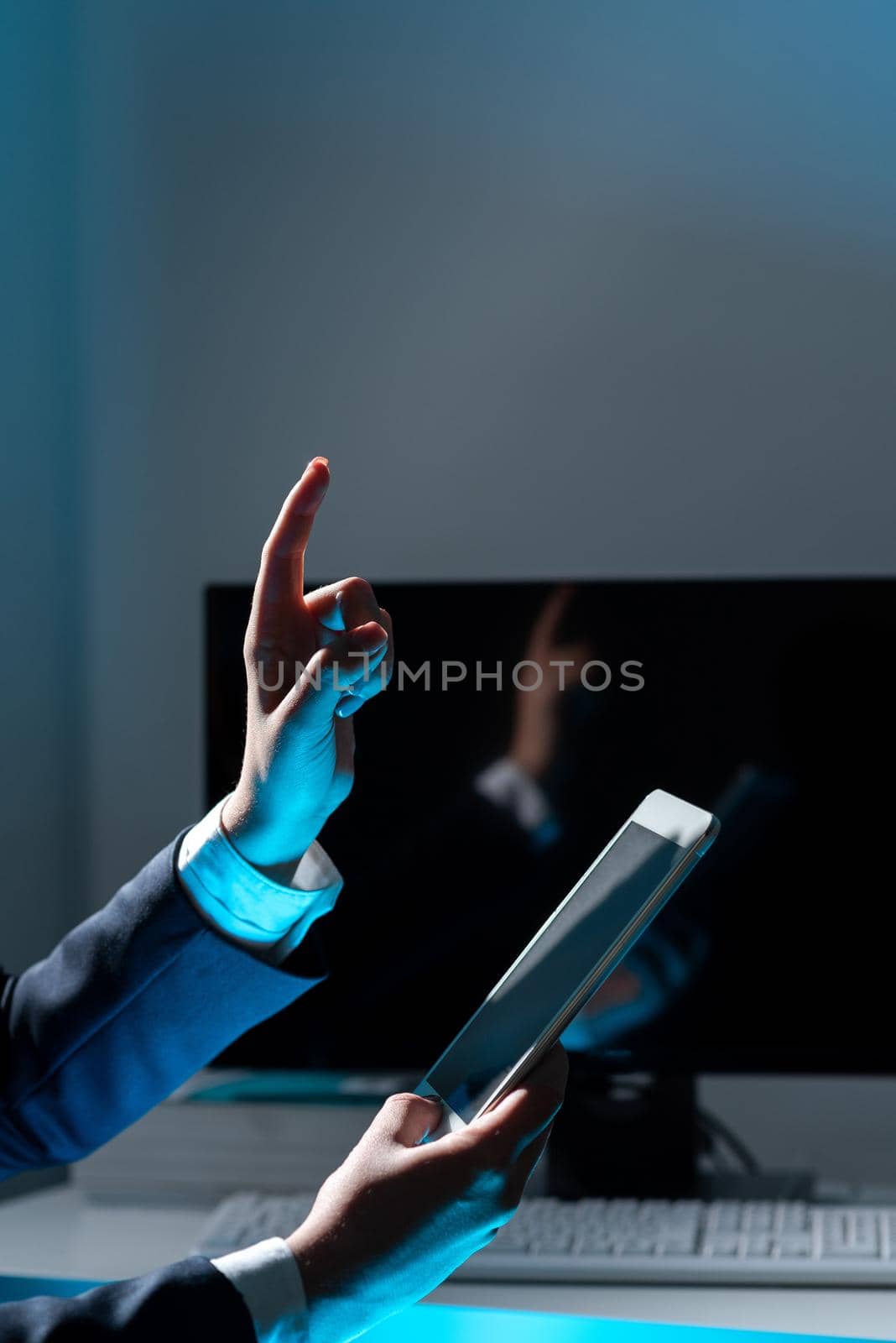 Businesswoman Holding Tablet And Pointing With One Finger On Important Message. Executive In Suit Presenting Crutial Information. Woman Showing Critical Announcement. by nialowwa