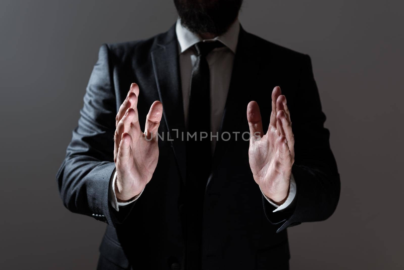 Businessman Holding Important Message Between Hands. Man In Suit Presenting Crutial Informations Among Palms. Executive Showing Recent Announcements. New Ideas Displayed. by nialowwa