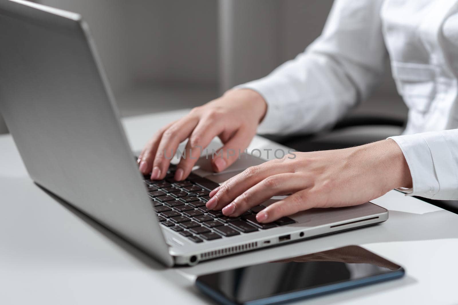 Businesswoman Typing Recent Updates On Lap Top Keyboard On Desk.