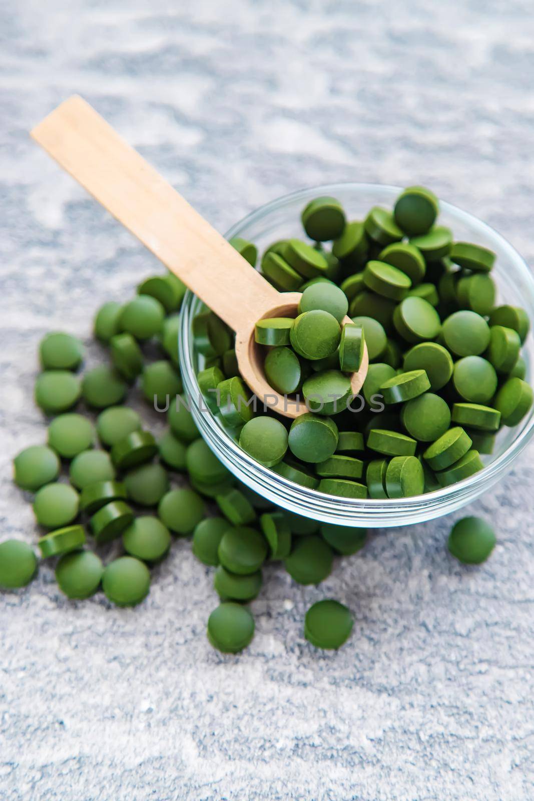 Green pills of chlorella and spirulina. Selective focus drink