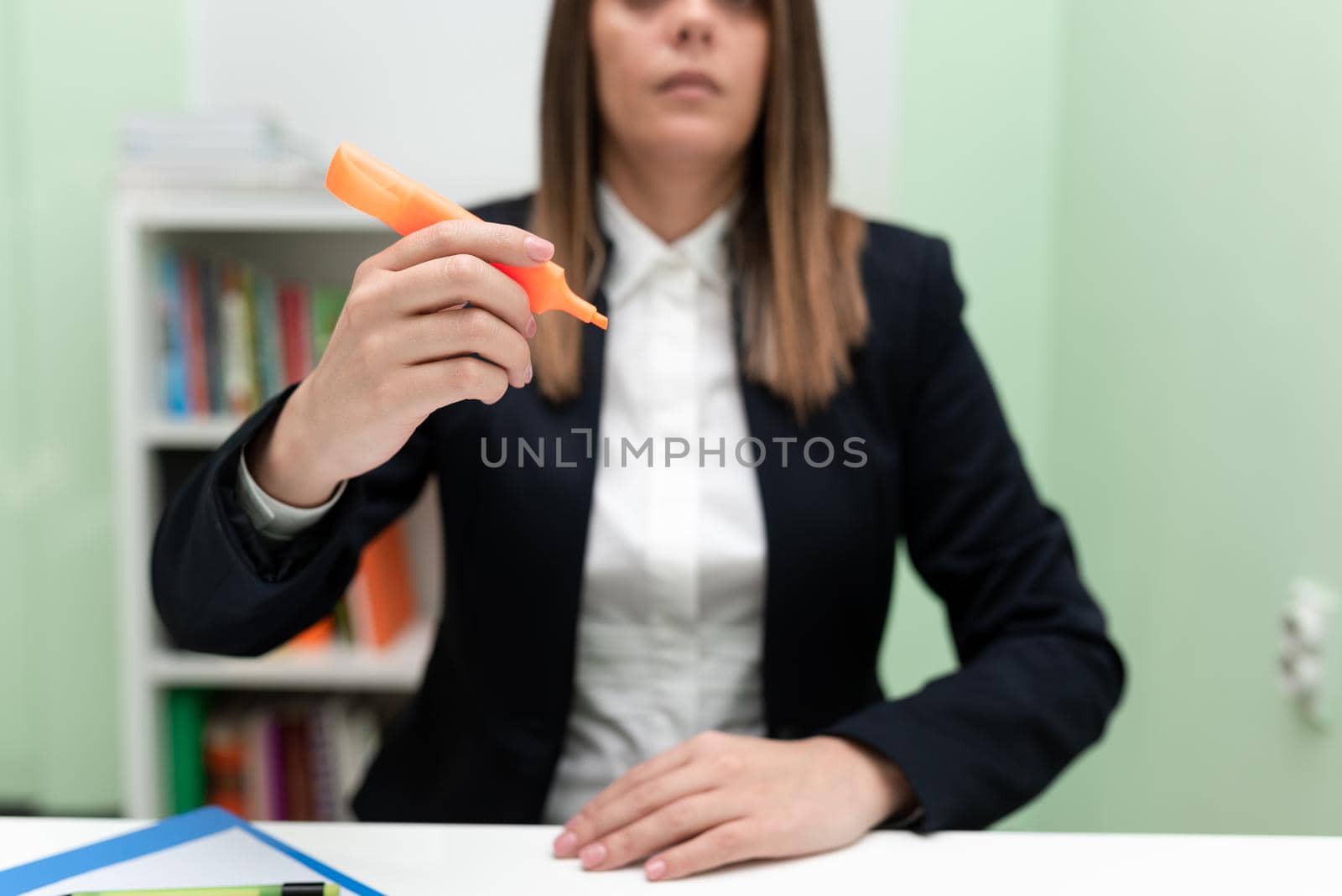 Businesswoman Holding Marker With One Hand And Pointing Important Ideas.