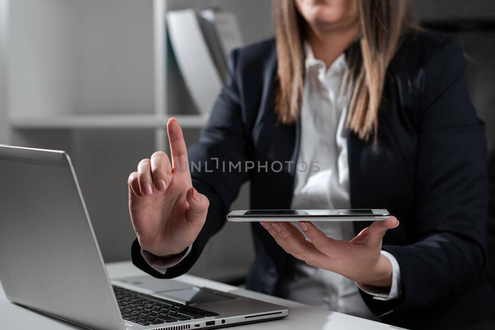 Woman Holding Tablet In One Hand And Pointing On News With One Finger.