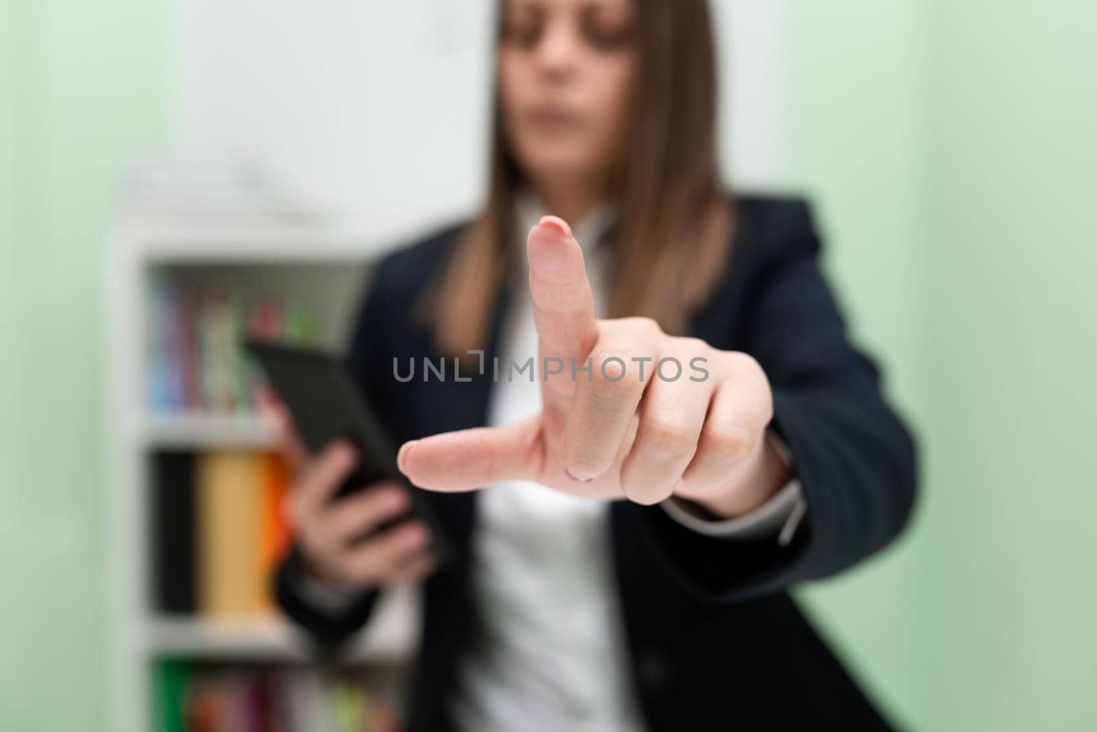 Businesswoman Holding Cellphone And Pointing New Ideas With One Finger.