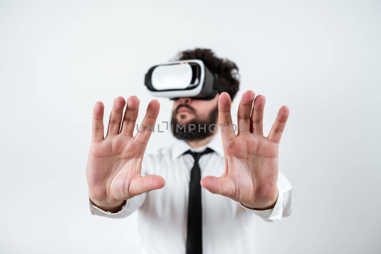 Man Wearing Vr Glasses And Presenting Important Messages Between Hands. Businessman Having Virtual Reality Eyeglasses And Showing Crutial Informations. by nialowwa