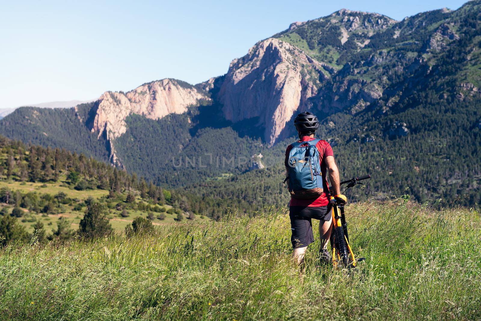 man with backpack and bike observes the mountains by raulmelldo