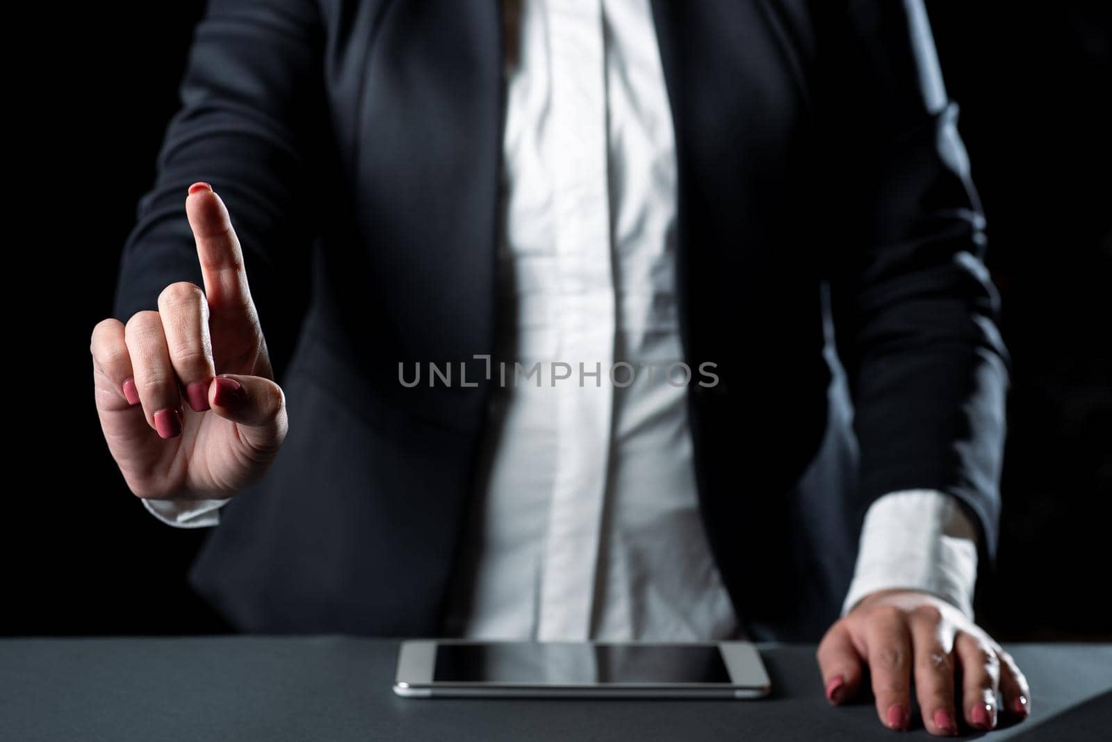 Businesswoman Having Tablet On Desk And Pointing Important Ideas With One Finger. Woman With Phone Showing Recent Updates. Executive Displaying Late News. by nialowwa