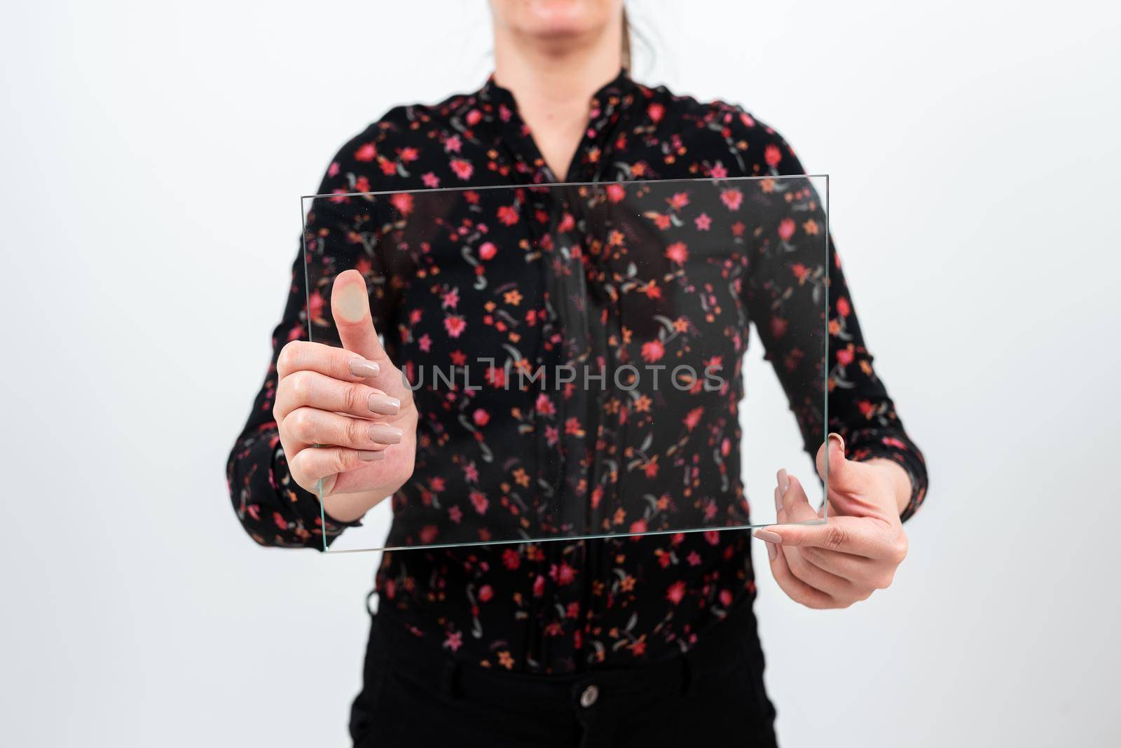 Female Professional Wearing Floral T-Shirt Holding Transparent Glass And Displaying Important Sales Data. Woman With Rectangular Banner Promoting The Company Brand. by nialowwa