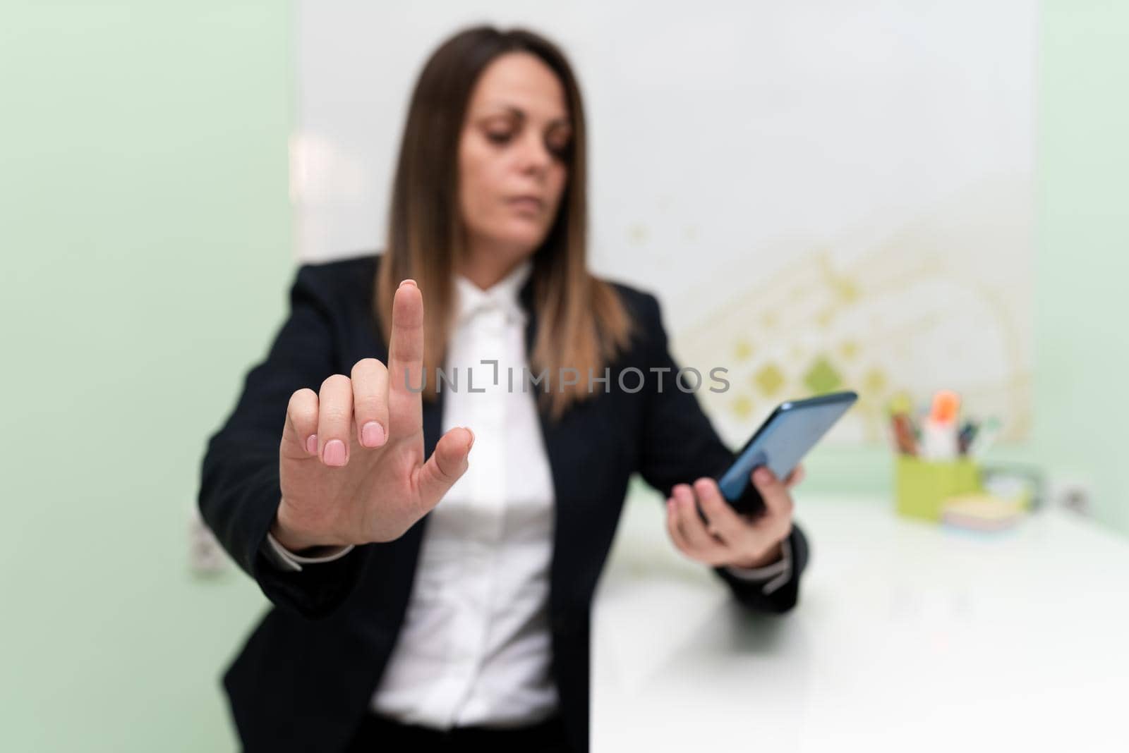 Businesswoman Holding Tablet With One Hand And Pointing Important Ideas With One Finger. Woman With Phone Showing Recent Updates. Executive Displaying Late News. by nialowwa