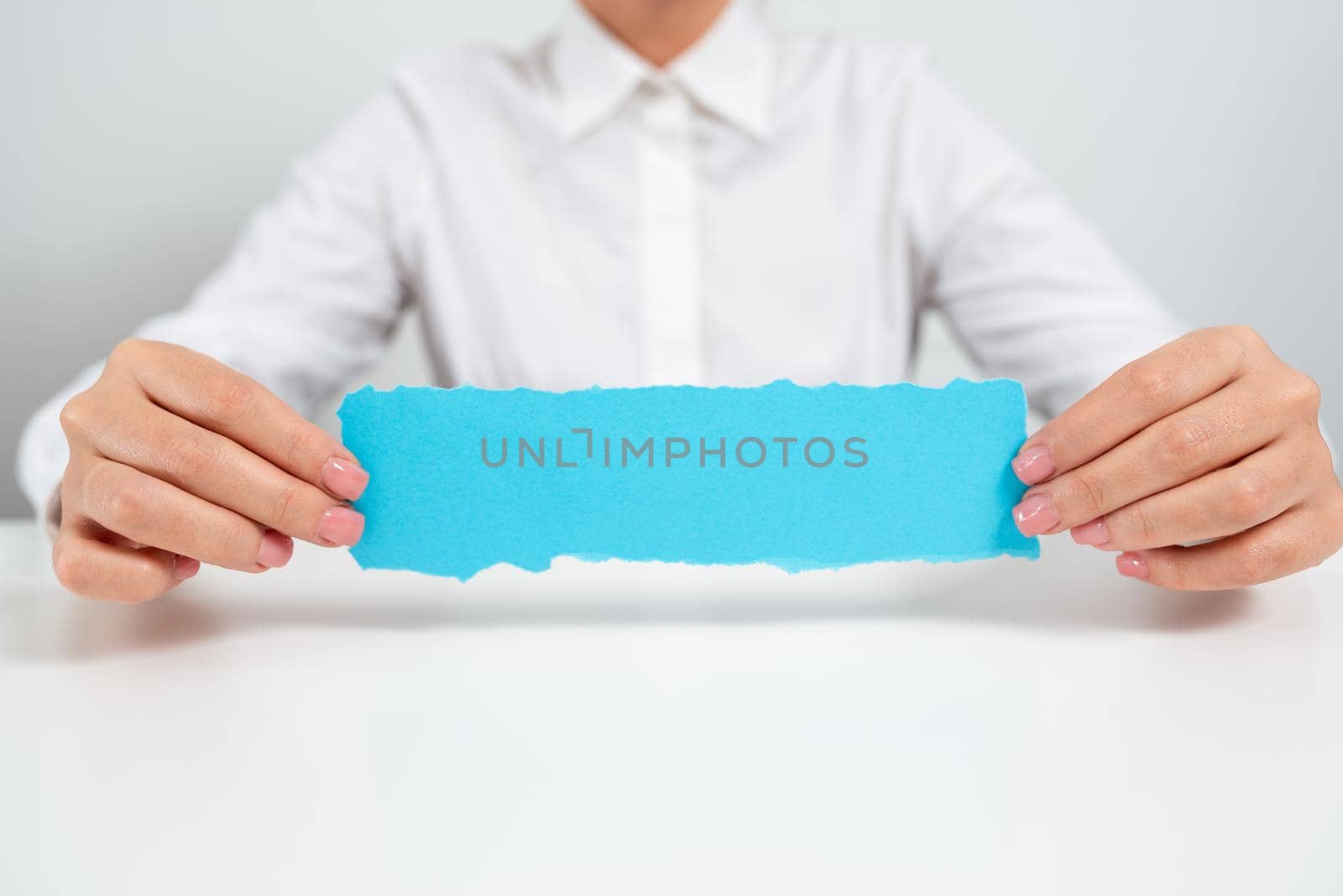 Businesswoman Holding Note With Important Message On Office Desk. Woman Presenting Crutial Information On Paper. Executive Showing Critical Announcement. by nialowwa