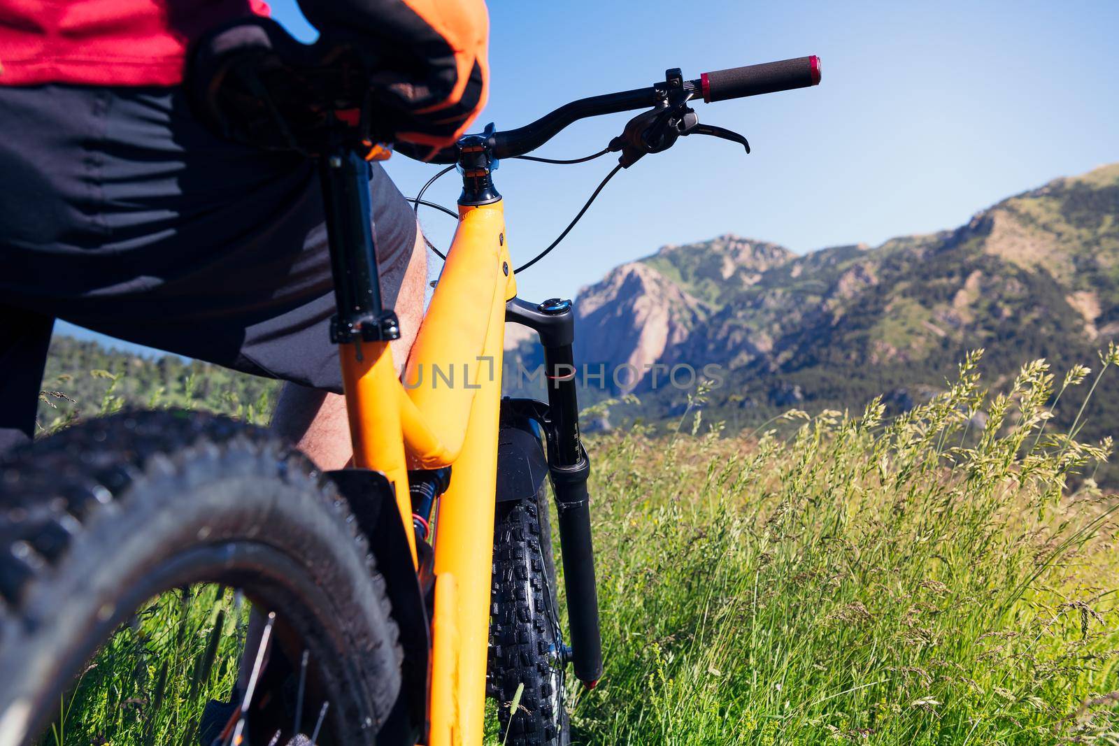 close up of a man observing the landscape and the mountains standing next to his mountain bike in the countryside, concept of sport and healthy lifestyle in nature, copy space for text