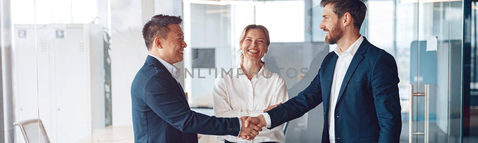 Young happy leader shaking hand with businessman for congratulation success presentation new project by Yaroslav_astakhov